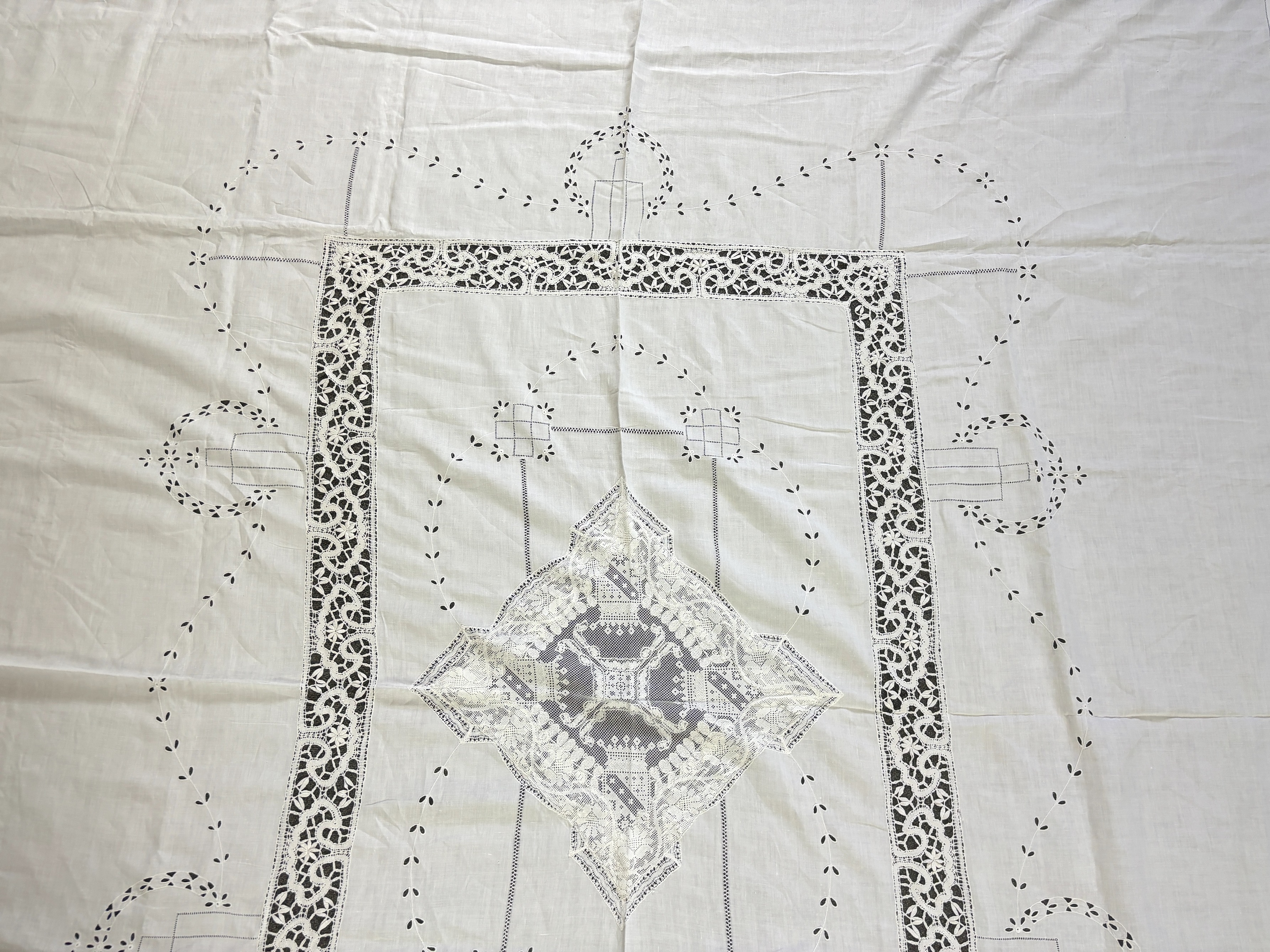 An Edwardian damask banqueting cloth 354cm long x 232 wide, worked with a central needle lace inserted cartouche, together with a smaller linen table cloth, 264cm long x 226cm wide, bordered with bobbin lace edges and si